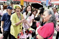 黃淑儀（左）與港台第五台節目總監陳婉紅（中）向在場市民送上康乃馨。